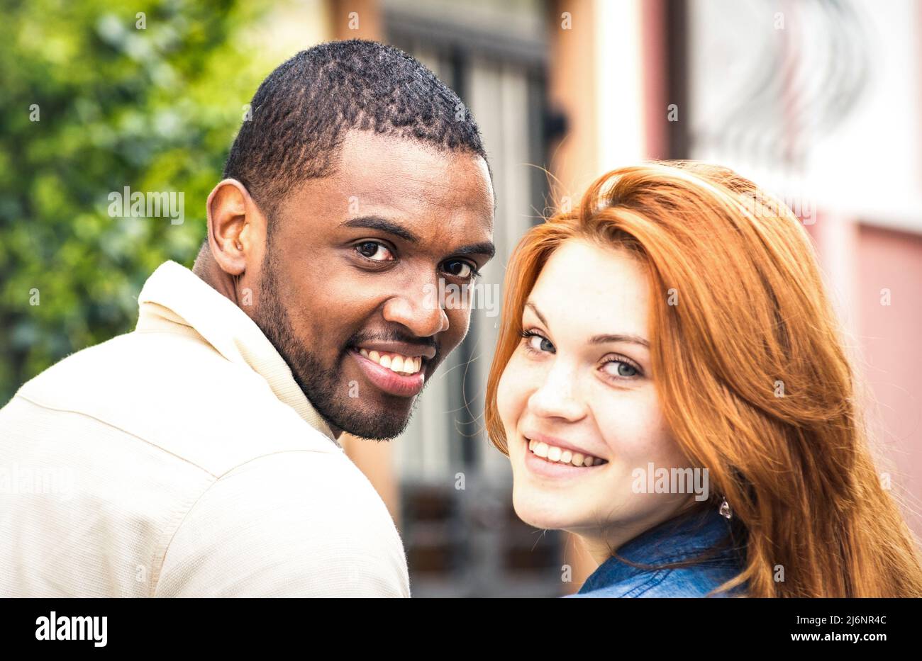 Portrait of multiethnic man and young woman walking outdoors - Happy multiracial couple at beginning of love story - Integration concept with boyfrien Stock Photo