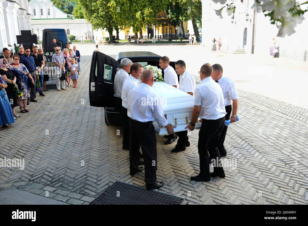 Funeral home workers carrying a coffin with a late in the church for ...