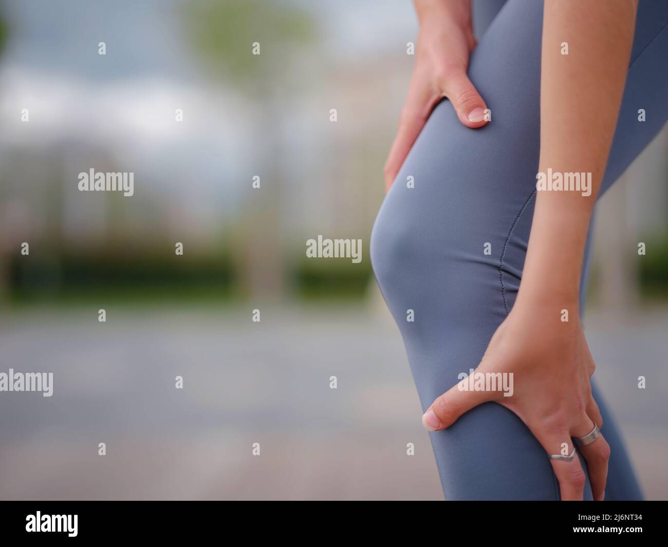 pain and from knee injury during morning run. Young woman