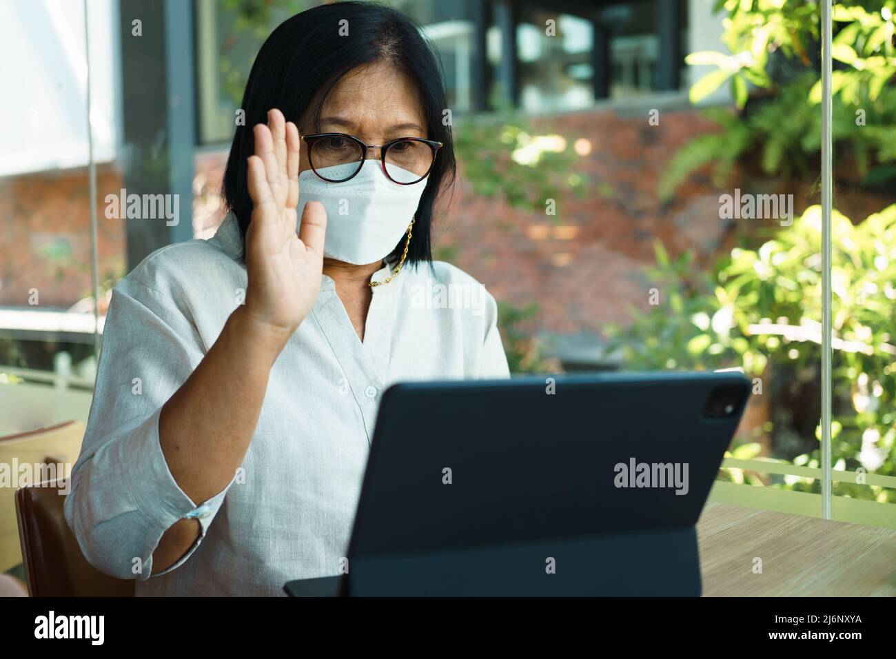senior woman aged 60-69 years using tablet, watching lesson Sign language online course communicate by conference video call from home, e-learning edu Stock Photo