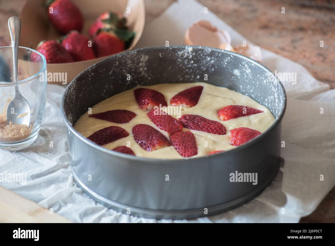 Homemade summer strawberry sponge cake in a baking form ready to bake. Stock Photo