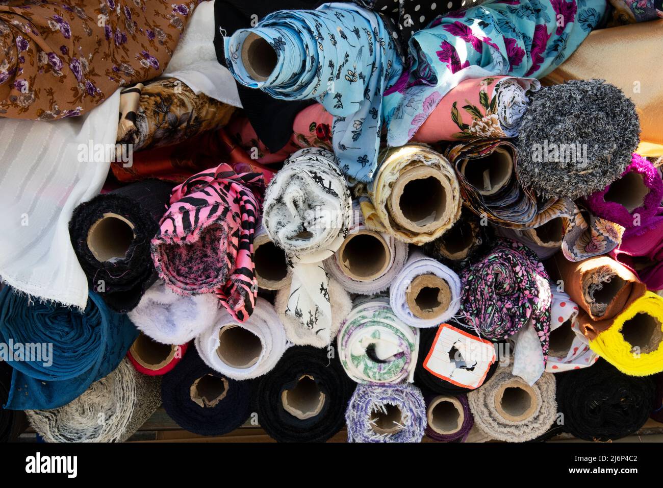 Fabric rolls or fabric bolts in various patterns and colors. Textiles