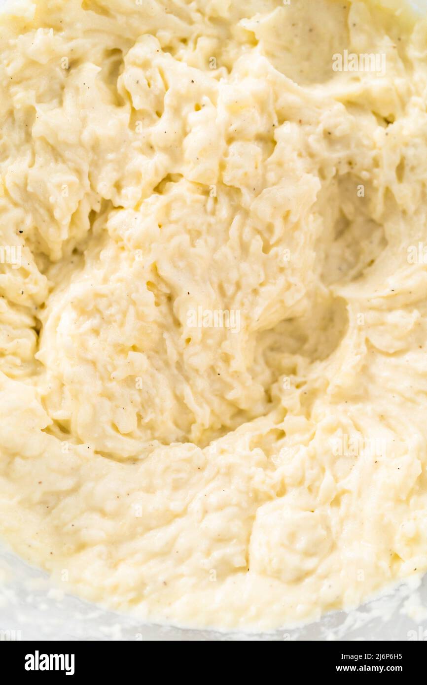 Mashed potatoes. Mashing cooked potatoes in a glass mixing bowl with a