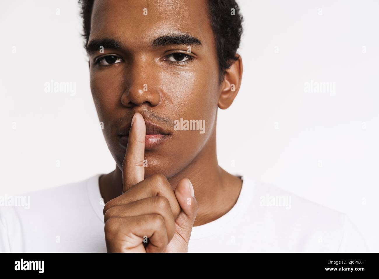 Black man showing silence gesture hi-res stock photography and 
