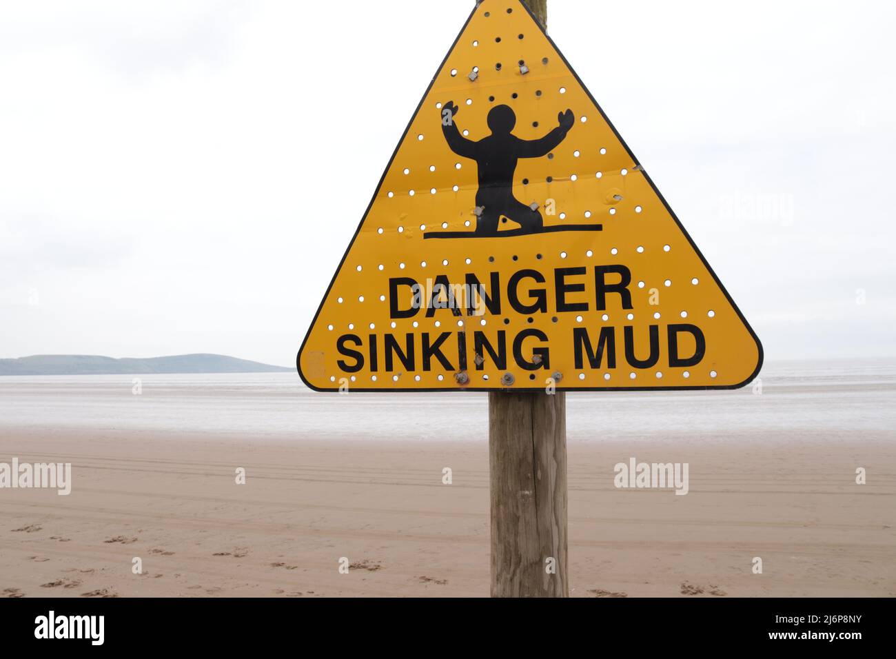 'DANGER SINKING MUD' sign with background of seemingly endless mud