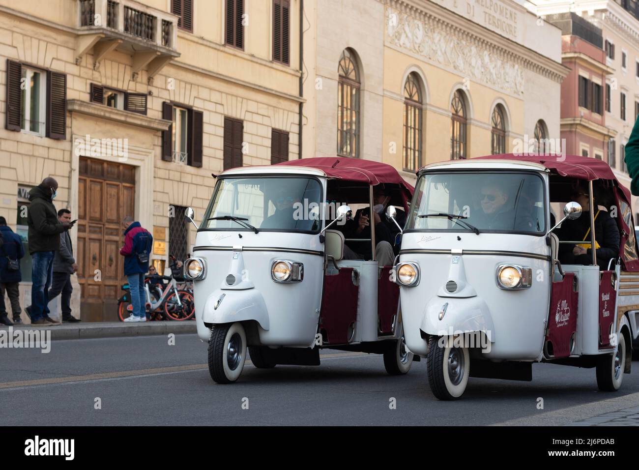 Rome, Italy - March 17th, 2022. Two white and red Calessino Ape Piaggio cars with family inside touring the city of Rome, Italy Stock Photo