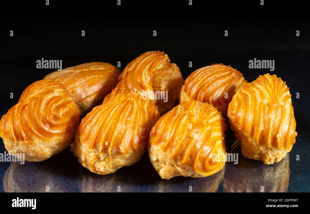 Sweet eclairs on the table with reflection. Food on a black background ...