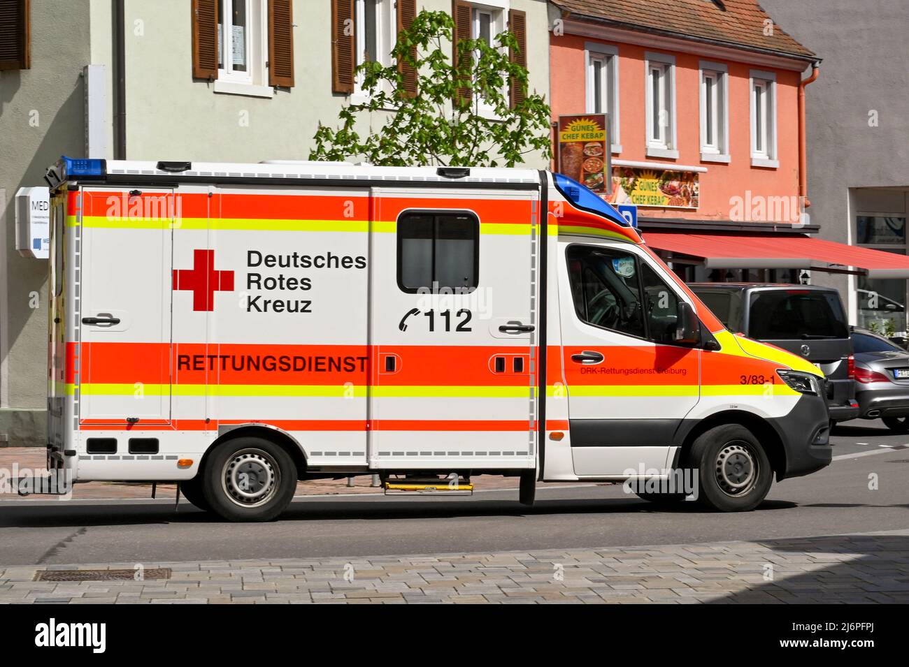 Breisach, Germany - April 2022: Emergency ambulance driving on one of the roads in the town centre Stock Photo