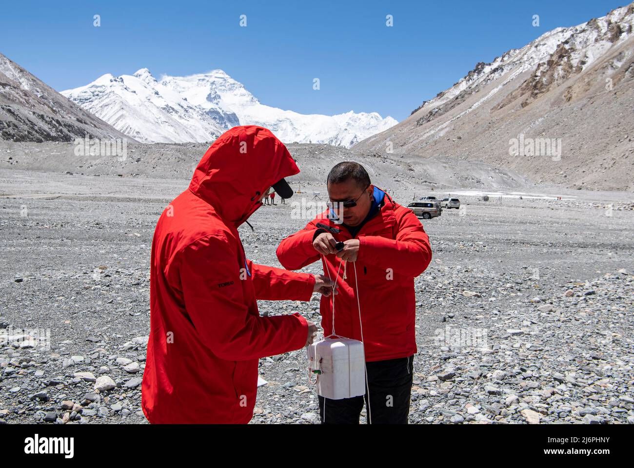 MOUNT QOMOLANGMA BASE CAMP, May 3, 2022 (Xinhua) -- Scientific research members prepare the radiosonde and ozonesonde to be attached to a weather balloon at the Mount Qomolangma base camp on May 3, 2022.  China has started a new comprehensive scientific expedition on Mount Qomolangma, the world's highest peak on the China-Nepal border.   Weather factors such as temperature, wind speed and humidity will directly affect the completion of scientific research tasks and the safety of research personnel at high altitude. Therefore, a meteorological support team has been launched in safeg Stock Photo