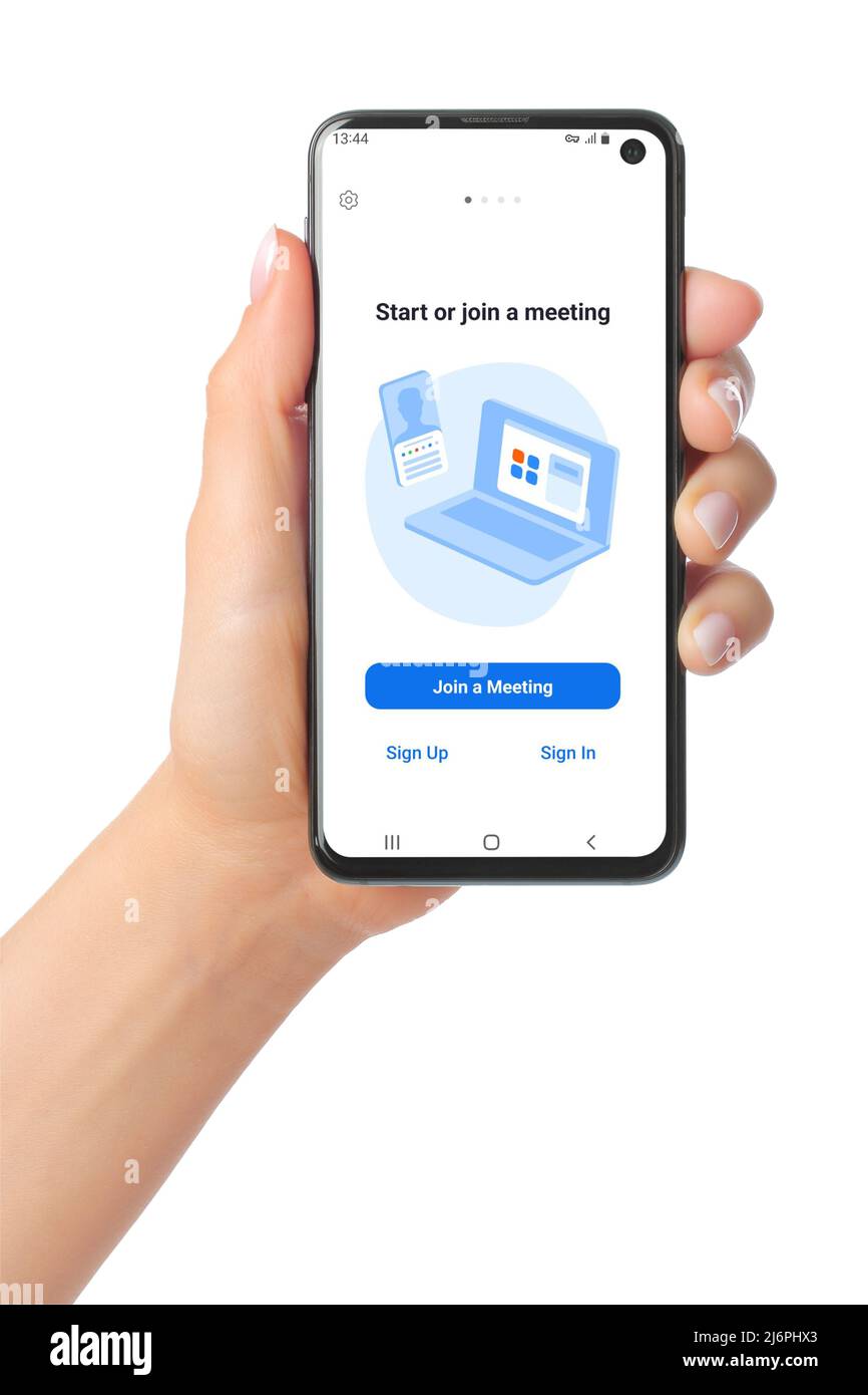 Kiev, Ukraine - January 20, 2022: Hand holds mobile phone with Zoom Meetings app on its screen. Zoom Meetings is a proprietary videotelephony software Stock Photo