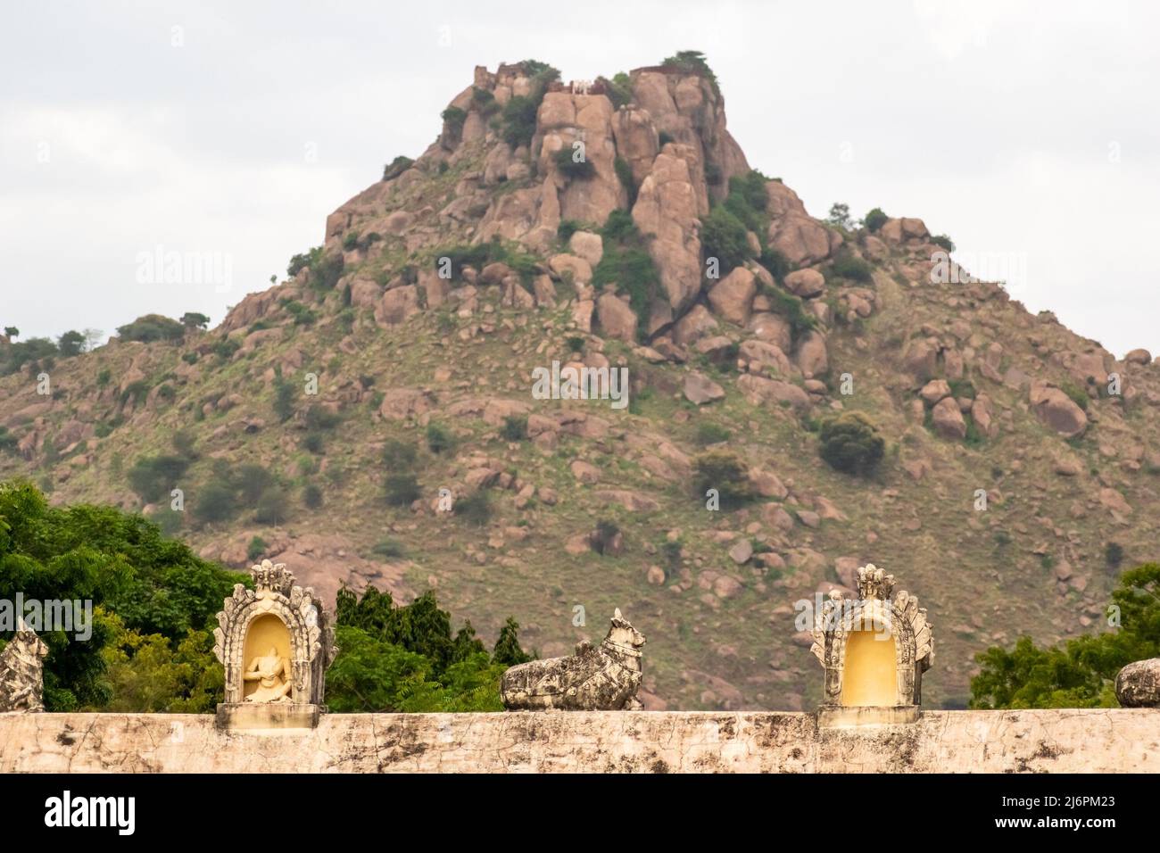 Ancient sculptures on the roof of the Hindu temple of Jalakdeswarar temple in the Vellore Fort complex with a rocky mountain in the background. Stock Photo
