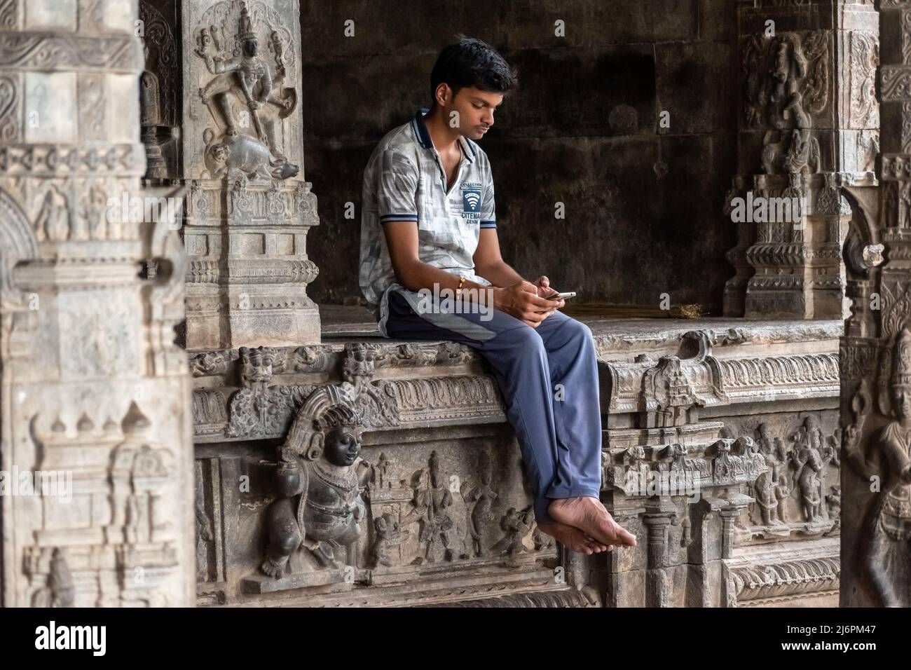Vellore, Tamil Nadu, India - September 2018: An Indian boy sitting alone in an ancient Hindu temple at the Vellore Fort. Stock Photo