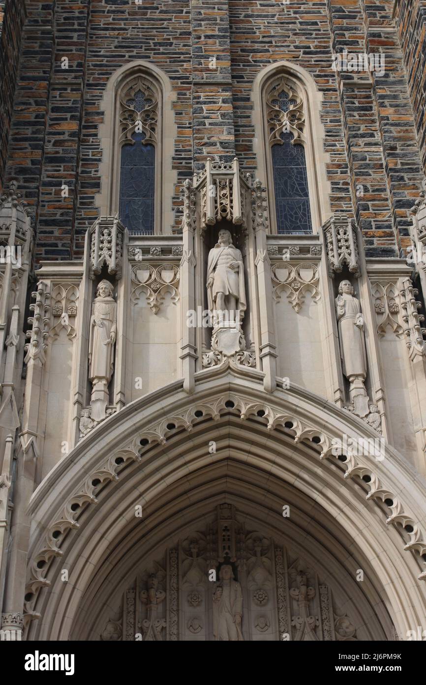 Close up of the top of the arched entryway and four statues above of the Duke University Chapel in Durham, North Carolina, USA Stock Photo