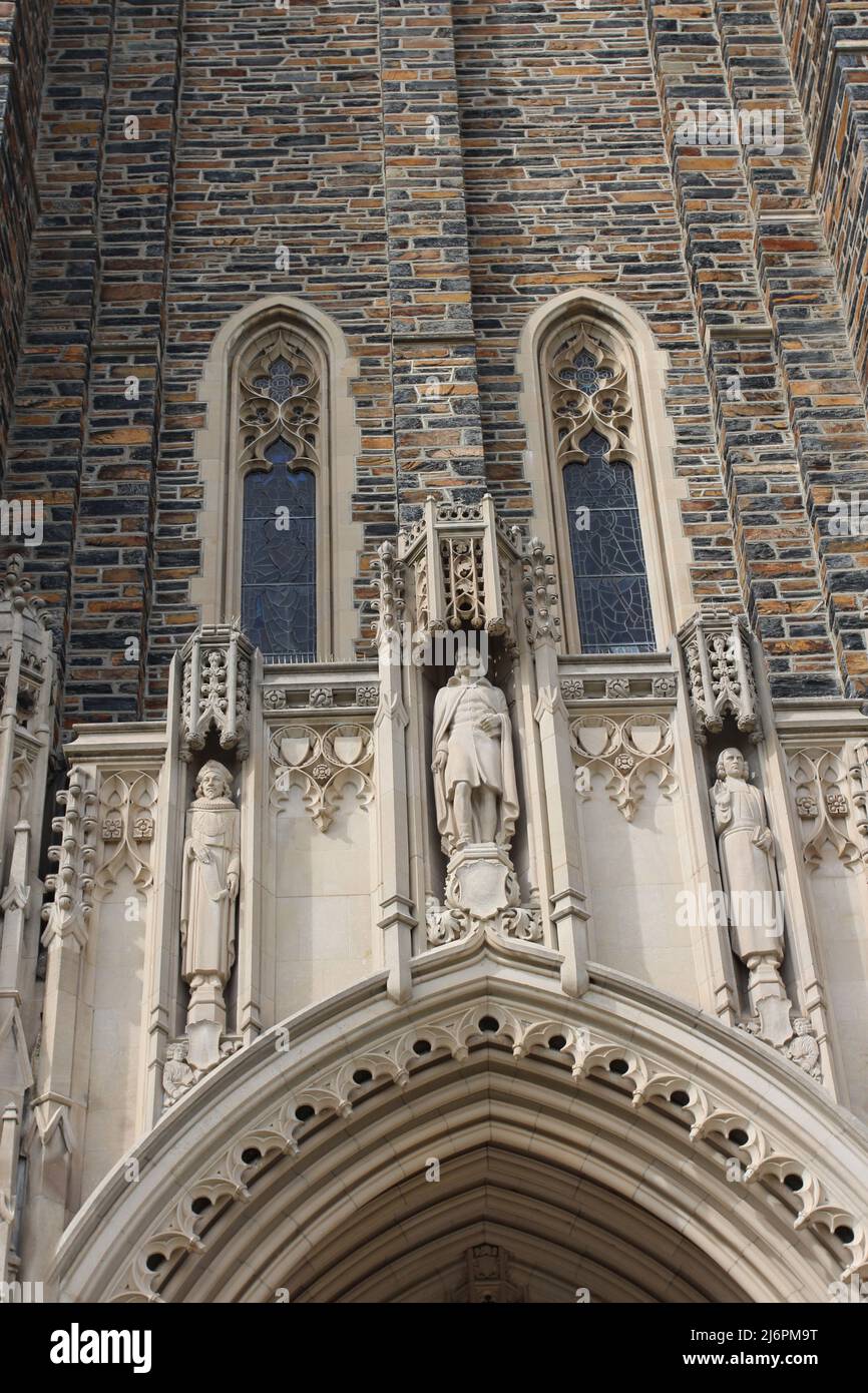 Close up of the top of the arched entryway and three statues above of the Duke University Chapel in Durham, North Carolina, USA Stock Photo