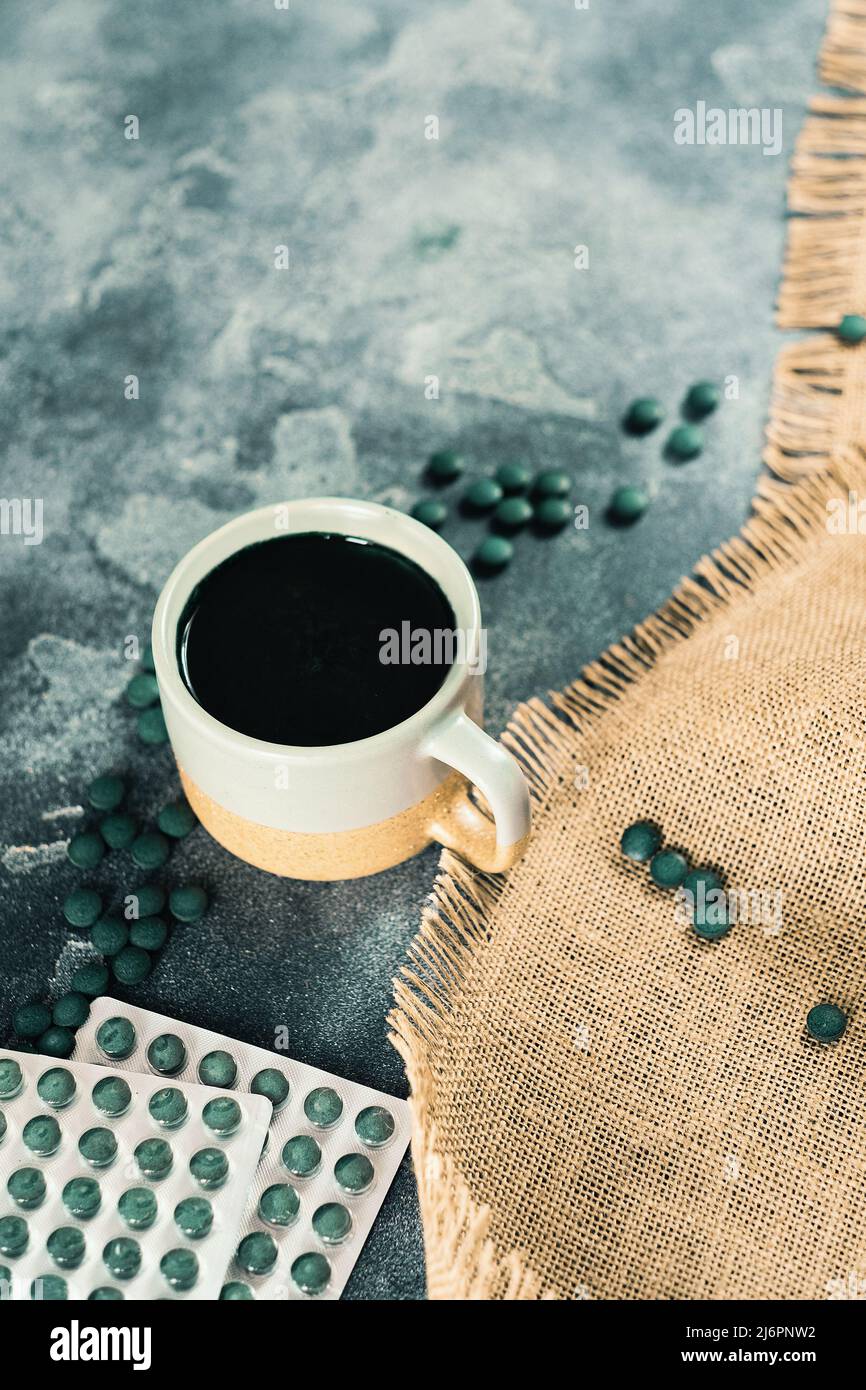 Spirulina pills tablets pack and a mug with a drink Stock Photo Alamy