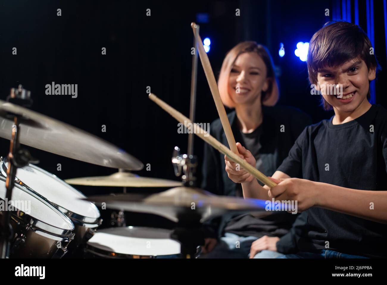 Young woman teaching boy to play drums Stock Photo Alamy