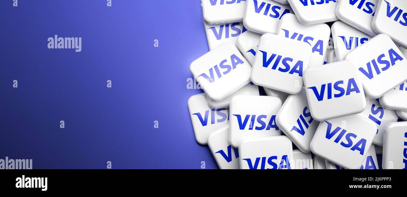 Logos of the credit card and financial services company VISA on a heap on a table. Copy space. Web banner format. Stock Photo
