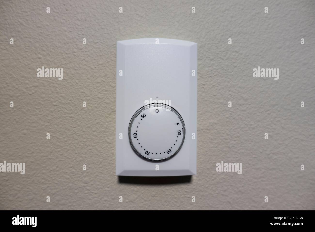 Close up view of a white air cooling and heating control panel on an off white colored wall inside a house Stock Photo