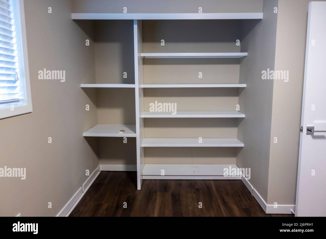 Straight on view of a white shelving system inside a closet in a