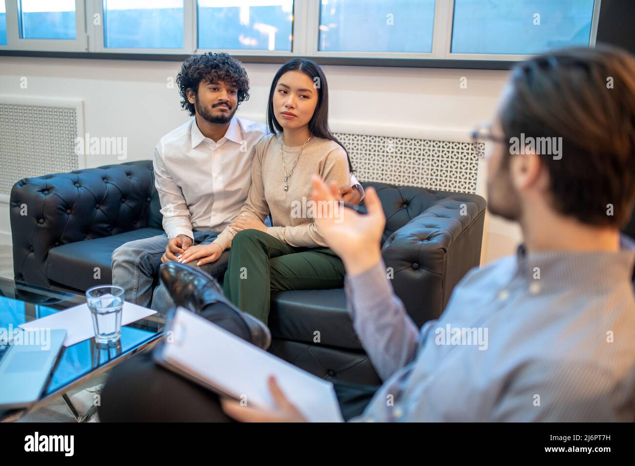 Young couple seated in the psychoanalyst office Stock Photo