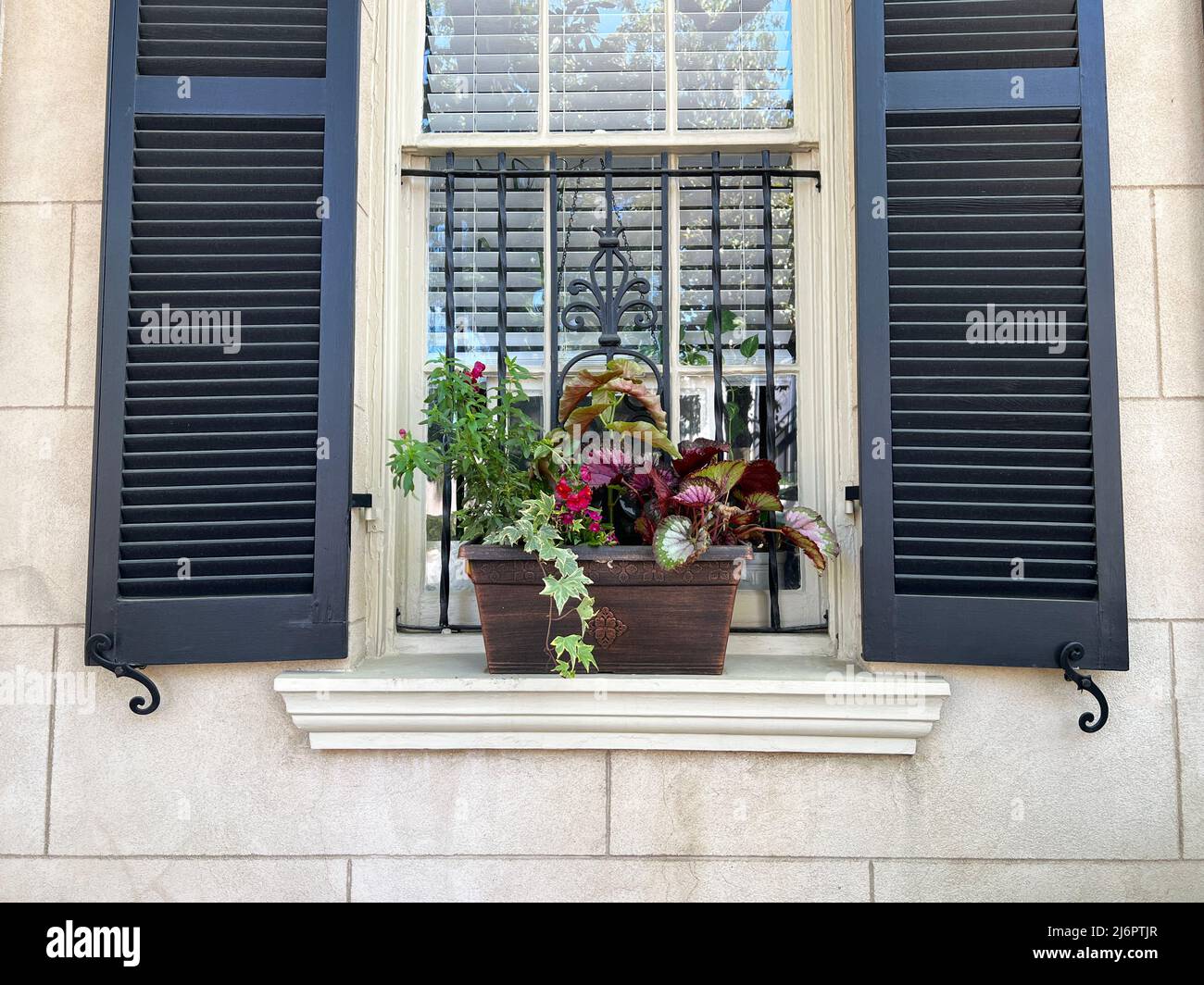 A window planter box seen in the historic district of Savannah, Georgia, a popular slow travel tourism destination in the southeastern United States. Stock Photo