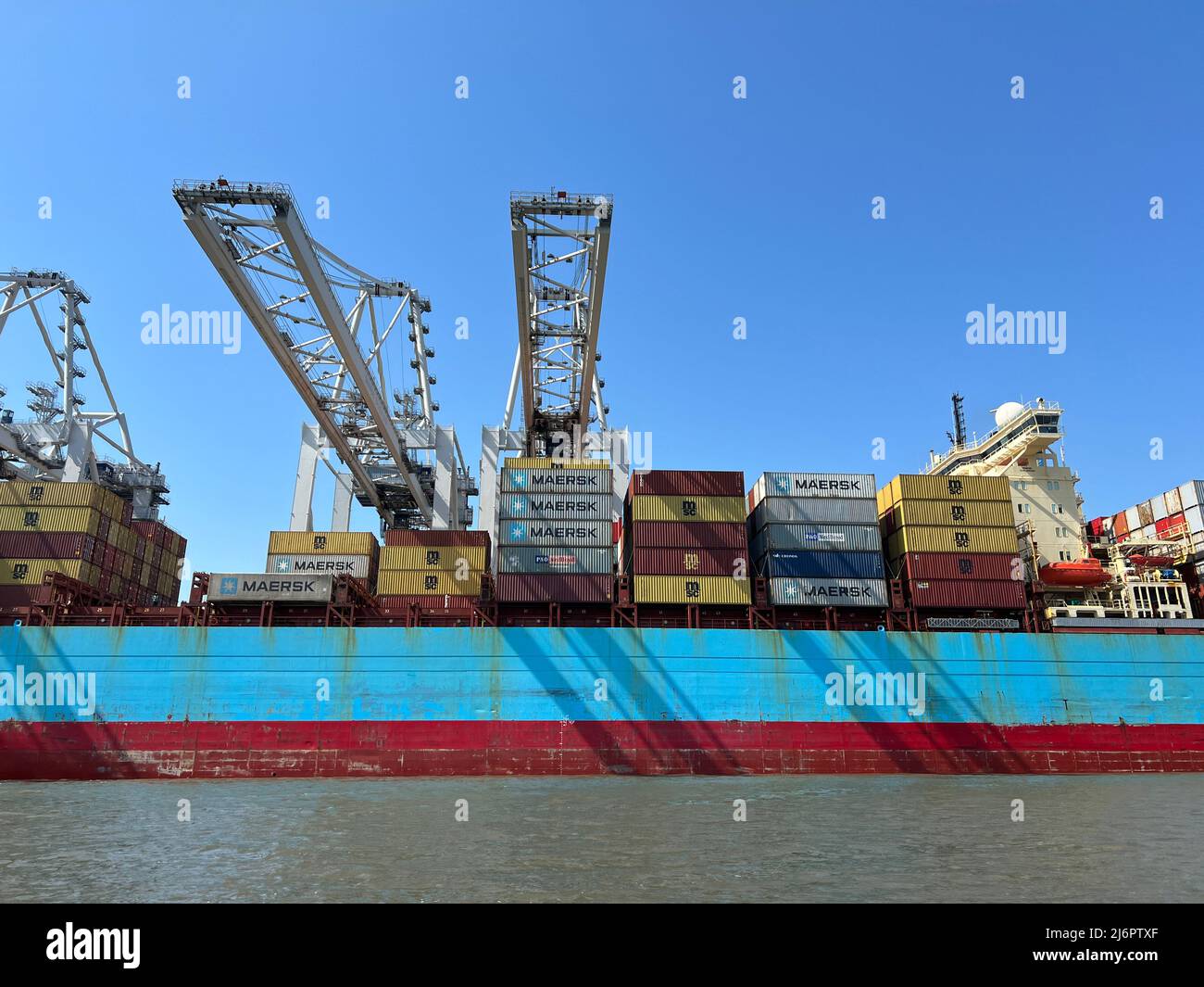 Savannah, Georgia, USA - March 29, 2022: Shipping containers loading and unloading in port are a part in the global supply chain. Stock Photo