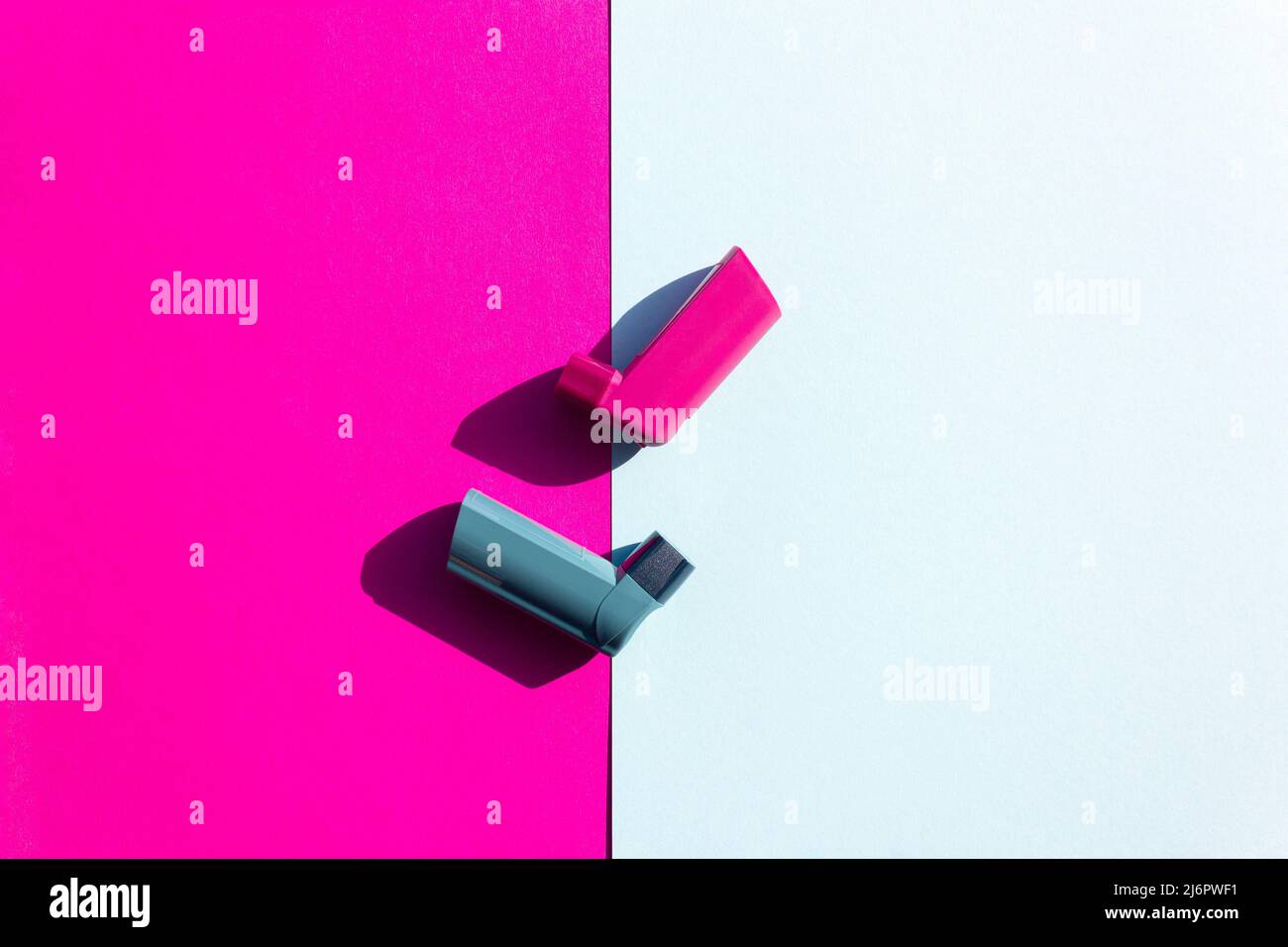 Creative asthma concept. Blue and pink asthma inhalers on a blue and pink background. Flat lay. Cope space. Stock Photo
