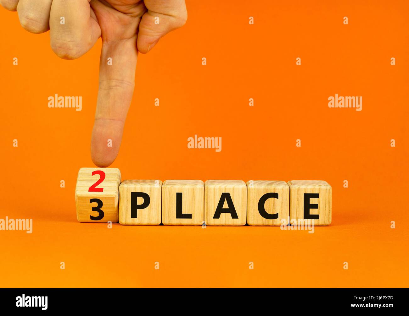 From 3 to 2 place symbol. Businessman turns wooden cubes and changes ...