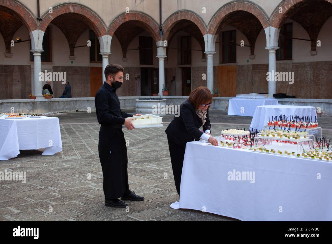 Venice, Italy - April, 20: Chef and her support worker prepare to make canapes starters for the buffet on April 20, 2022 Stock Photo