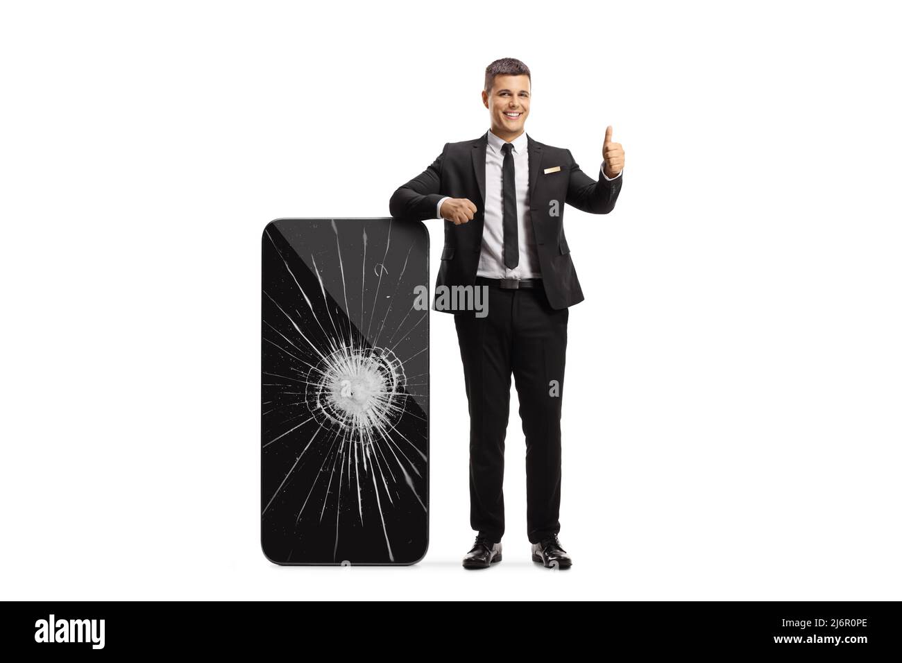 Professional man in leaning on a big smartphone with a broken screen and gesturing thumbs up isolated on white background Stock Photo