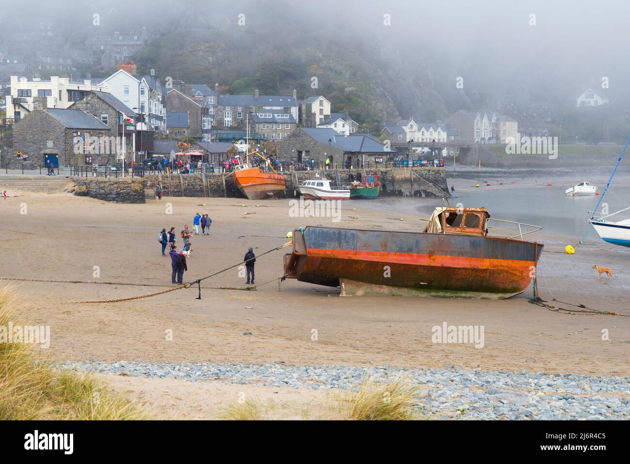 People on the beach at Barmouth with low cloud sea mist over the town Stock Photo