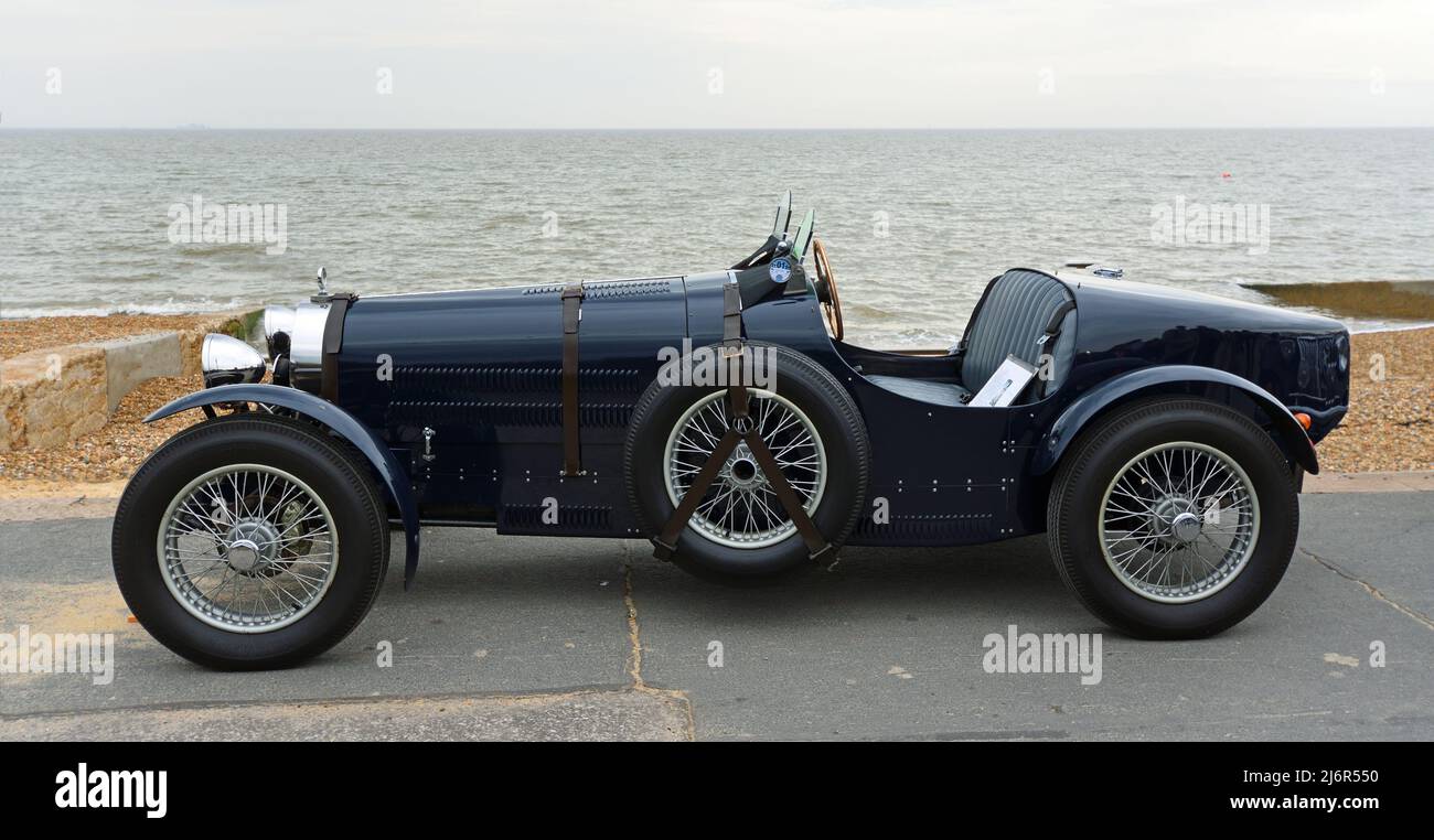 Classic  Teal Bugatti racing car parked on seafront promenade sea in background. Stock Photo