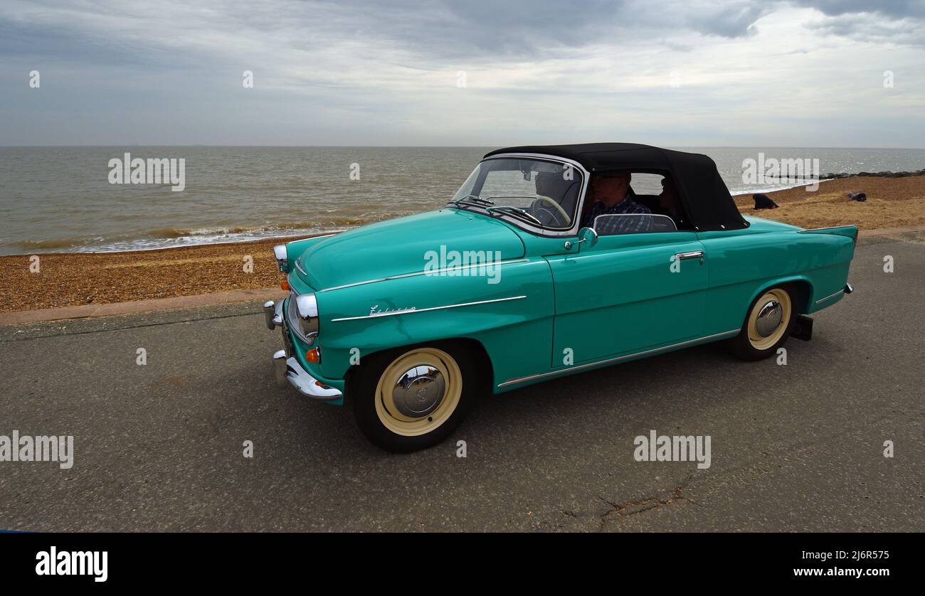 Classic  Skoda Felicia Convertible being driven on seafront promenade beach and sea in the background. Stock Photo