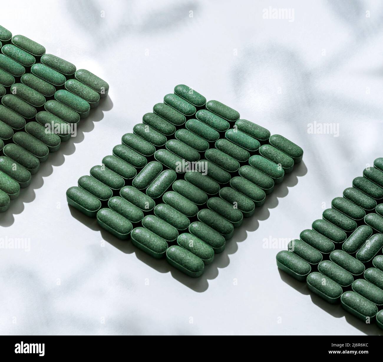pattern of pills of chlorella, spirulina, barley grass closeup lined