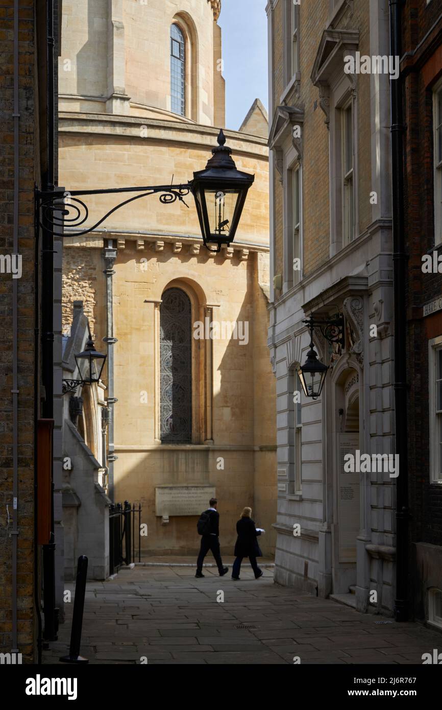 Two people walking past Temple Church and Farrar's Building, Temple, London, UK. Stock Photo
