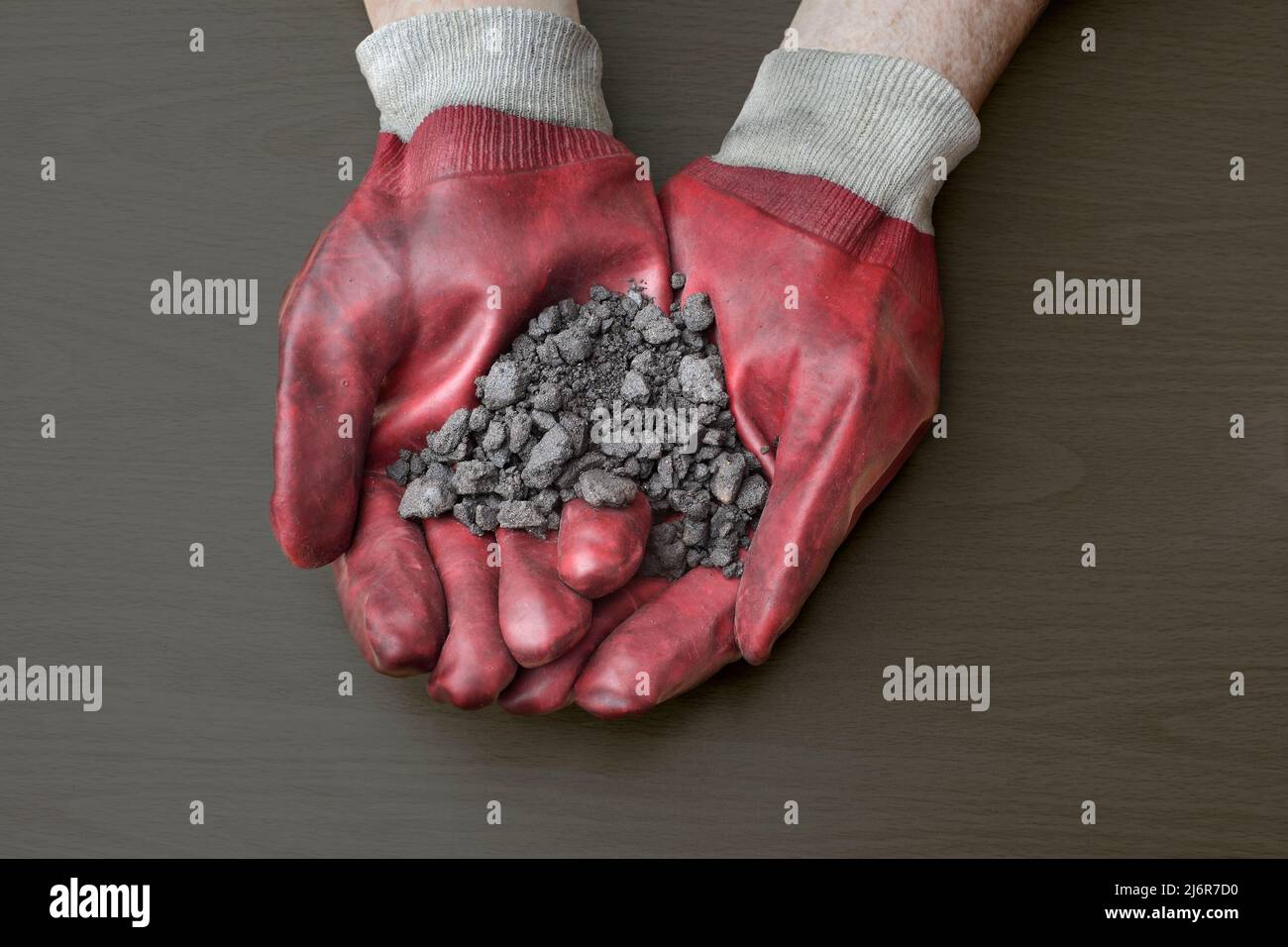 A handful of oil sand, mined from the Athabasca oil sands deposits near Fort McMurray, Alberta, Canada. Stock Photo