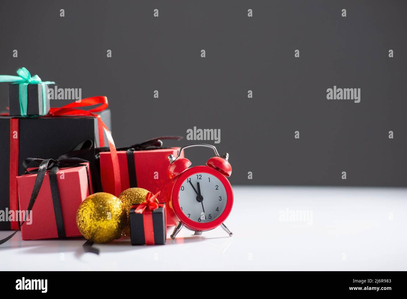 New Year's still life with watches and gifts on a white-dark background Stock Photo