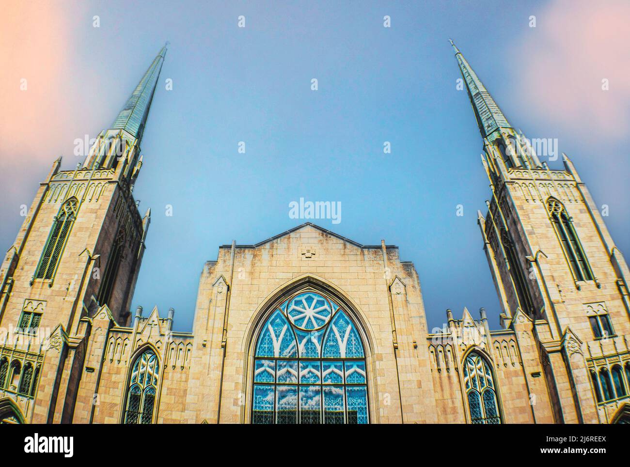 Copper steeples and stained glass windows of Gothic church with wide angle-fish eye lens  Room for copy and perspective. Stock Photo