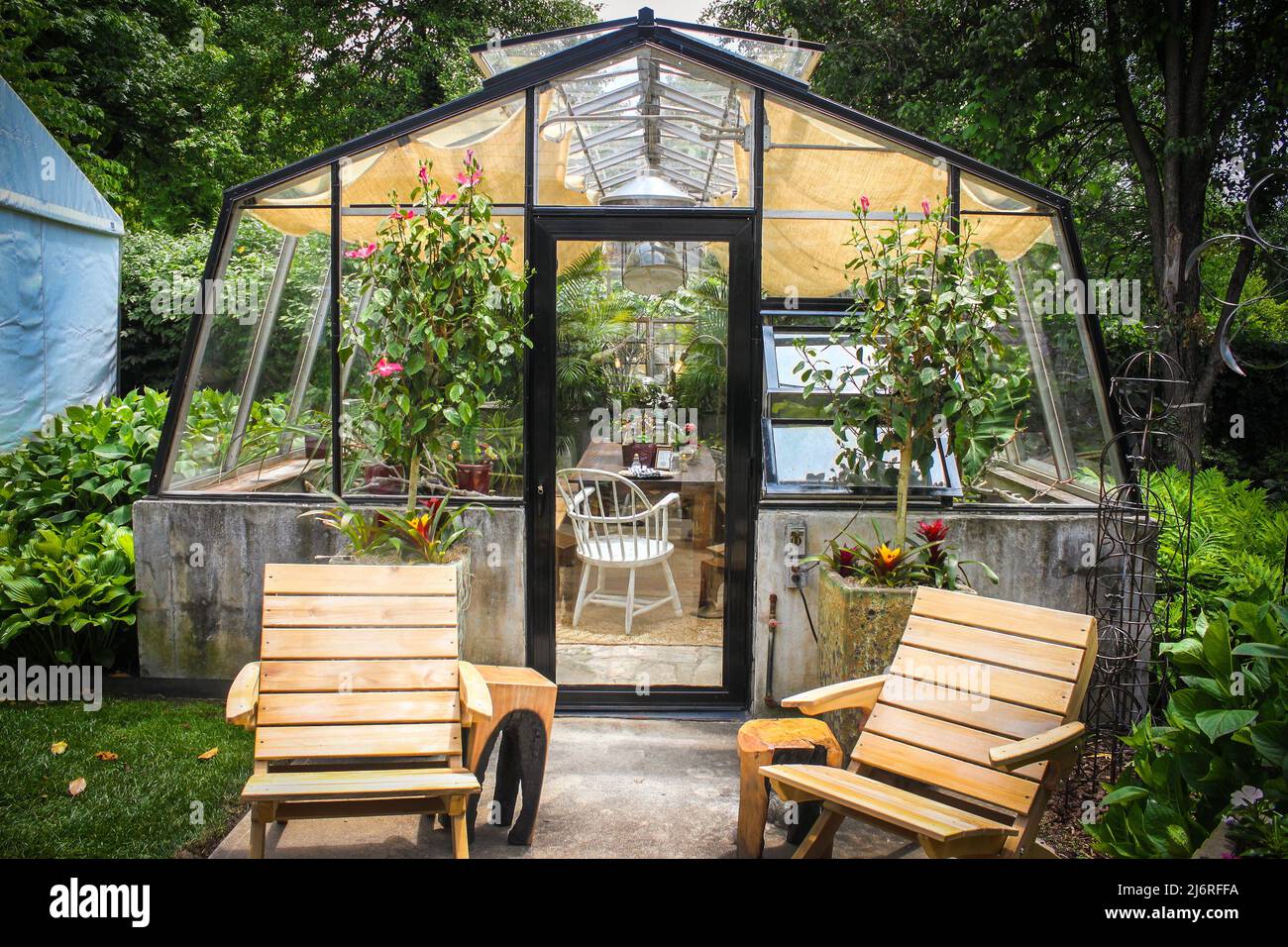 Cute and homey greenhouse used as an outdoor room surrounded by trees