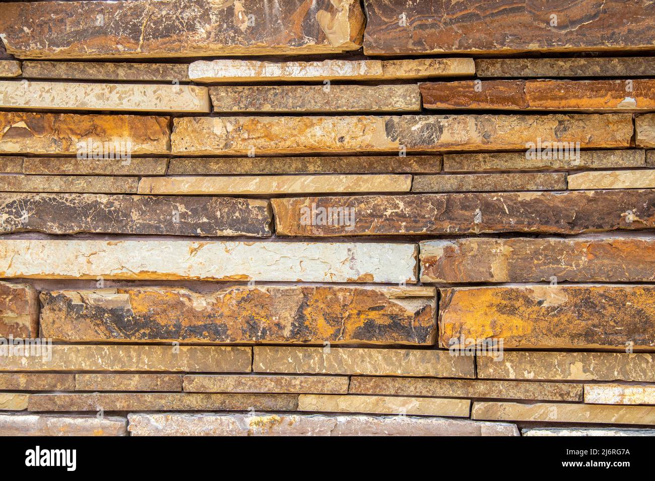 Dry stacked stone wall made of large slabs of colorful sandstone background Stock Photo