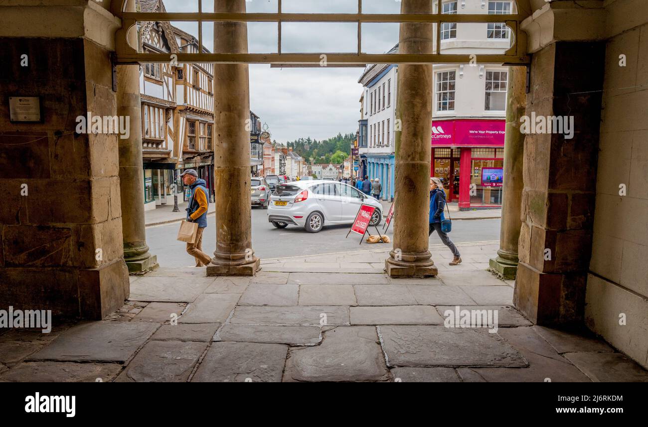 The stone pillars of Ludlow town hall and museum looking down broad street, Ludlow, Shropshire, England. Stock Photo