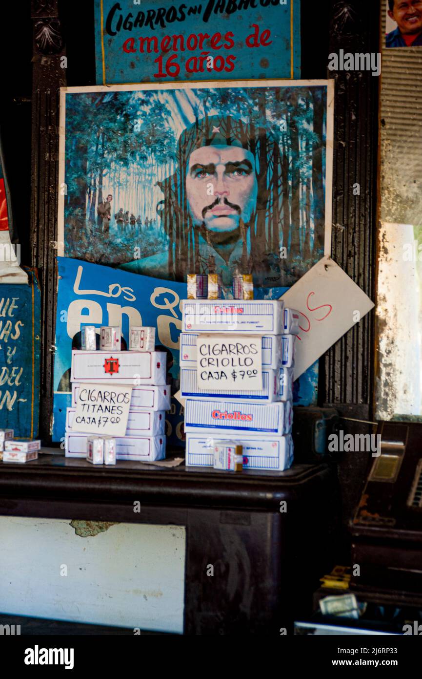 Cuban cigarets for sale in a shop in Havana, Cuba featuring a mural drawing of Cuban revolutionary leader Che Guevara. Stock Photo