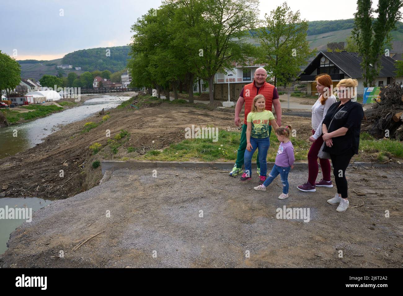 02 May 2022, Rhineland-Palatinate, Ahrweiler: Valentyna Ridvanskaya (m) and her family, husband Yuri (r), mother-in-law Svitlana, and children Polina and Uliana, stand in front of the remains of the Ahrtor Bridge. The family is from near Kiev and recently fled the war in Ukraine. At the moment, the family is helping out with the aid organization 'Ark', which cares for people affected by the flood disaster. Photo: Thomas Frey/dpa Stock Photo