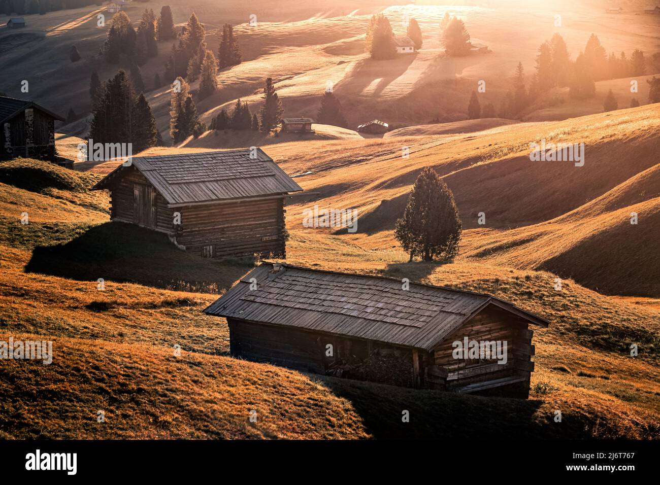 Alpe di Siusi, Italy - Traditional wooden cabins at Seiser Alm, an alpine meadow on a warm autumn sunrise at the Italian Dolomites, South Tyrol Stock Photo