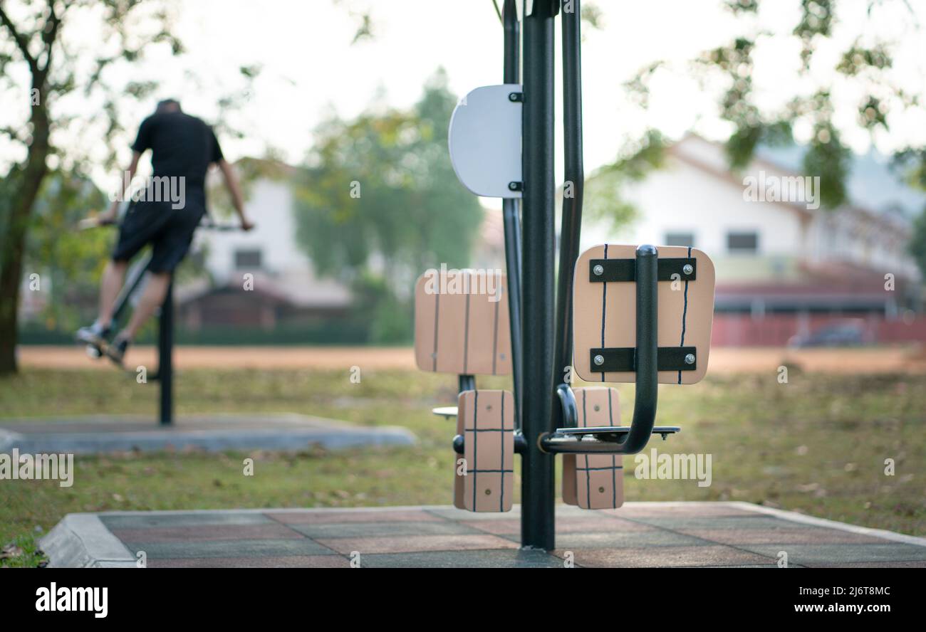 Fitness equipment, outdoor with out of focus man exercising at the background. Sports or healthy lifestyle concept. Stock Photo