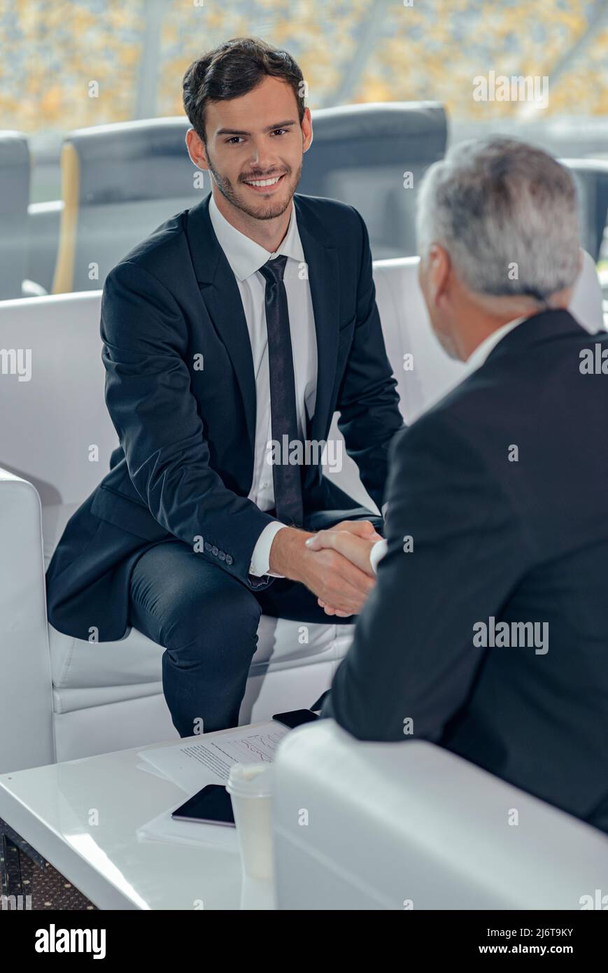 Vertical photo of business men shaking hands in office Stock Photo