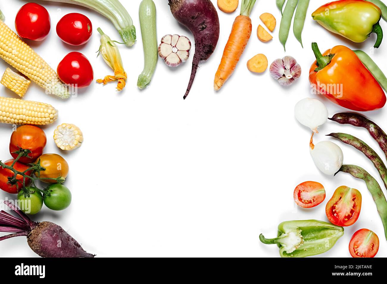 Healthy eating concept. Tomatoes, onion, carrot, garlic, red beet, pepper, maize and green haricot on white studio background wall. Creative layout ma Stock Photo