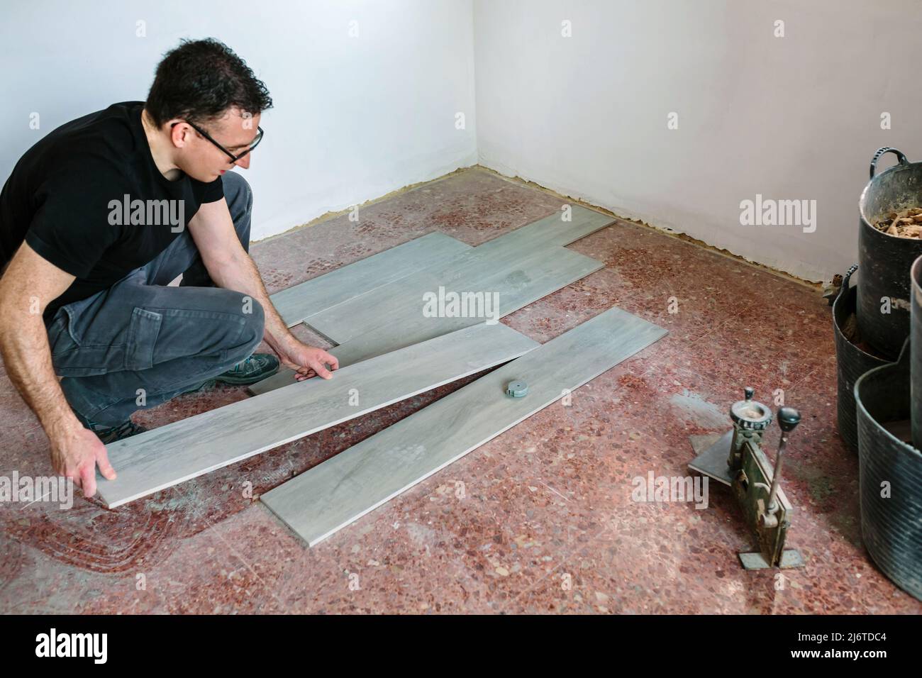 Bricklayer placing tiles to install a floor Stock Photo Alamy