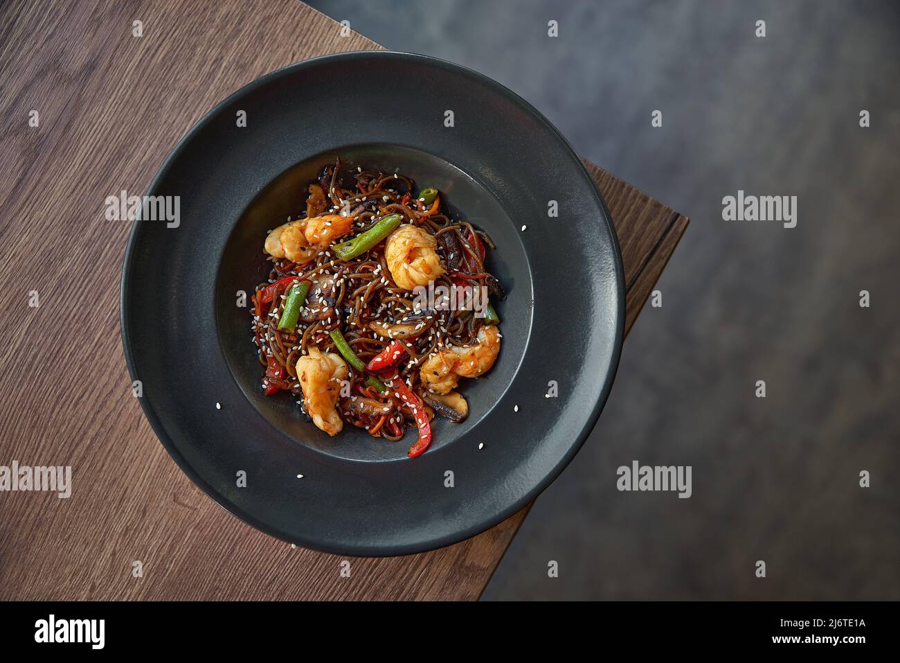 Funchoza with shrimp and vegetables on the table, copy space. Buckwheat