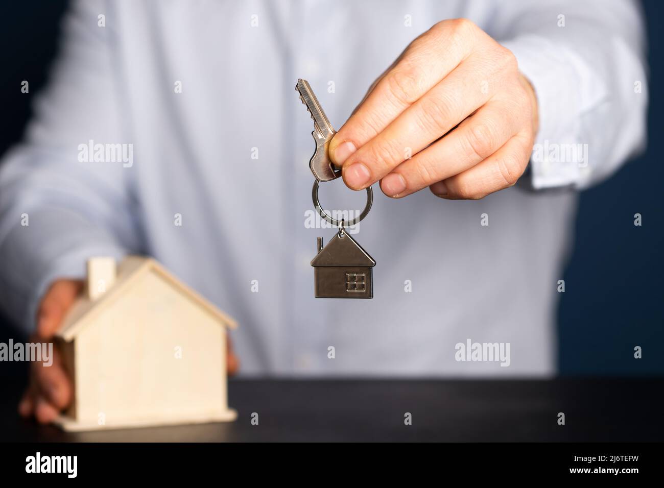 Businessman holding wooden house model and house key.Real estate, home ...